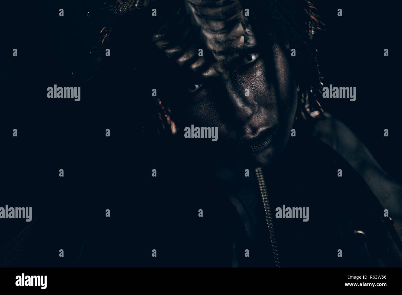 Portrait de jeune femme à l'image d'alien humanoïde extraterrestre et avec des cornes sur la tête et des yeux démoniaques. Banque D'Images