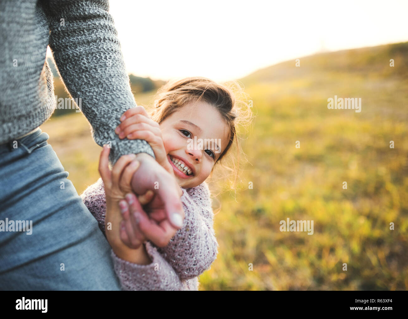 Une petite fille avec père méconnaissable en automne la nature, s'amusant. Banque D'Images