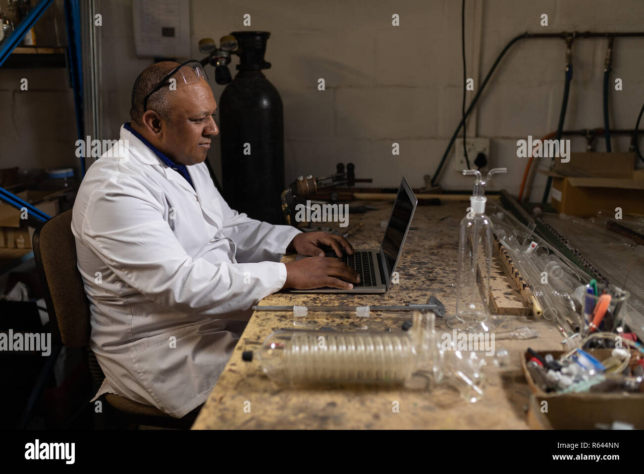 Worker using laptop in glass factory Banque D'Images
