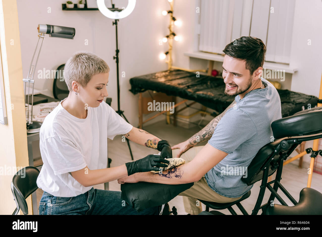La transmission de l'homme en discutant avec l'artiste de tatouage Banque D'Images