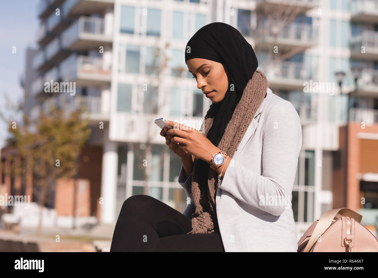 Hijab woman using mobile phone dans la ville Banque D'Images