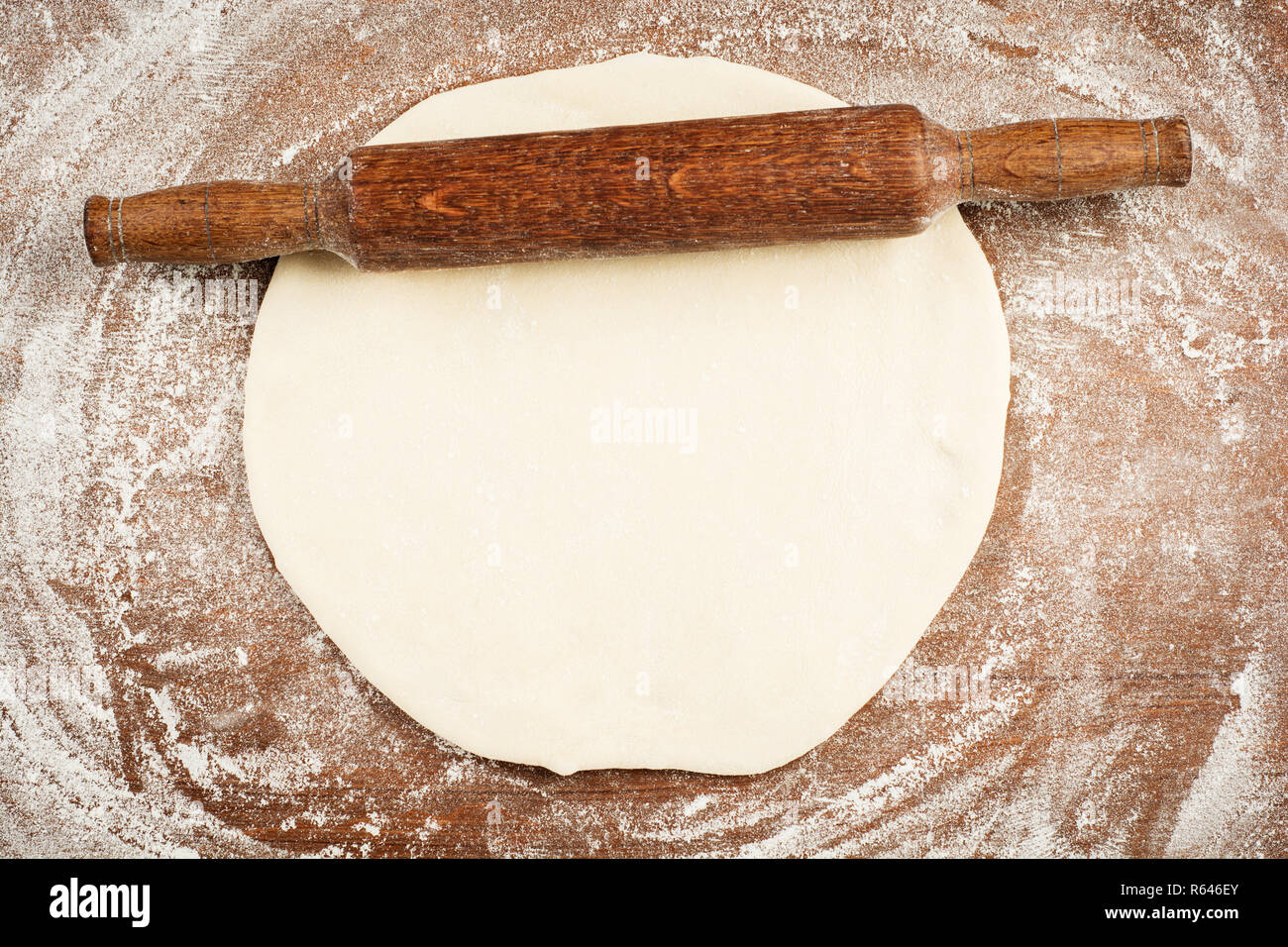 Bloc de pâtisserie fraîchement mis en place sur un plan de travail fariné avec un rouleau à pâtisserie en bois close up Banque D'Images