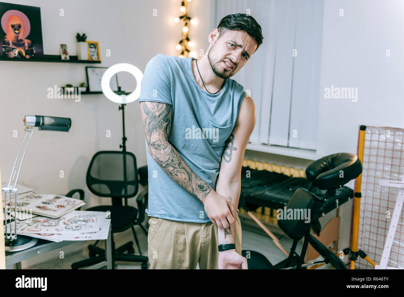 Malheureux beau mec avoir inconvénients après la farce nouveau tatouage Banque D'Images