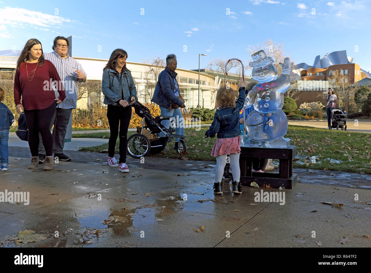 Jeune enfant vagues pour une sculpture de glace fondante les fées au 2018 Wade Park Wintertide festival à Cleveland, Ohio, USA. Banque D'Images