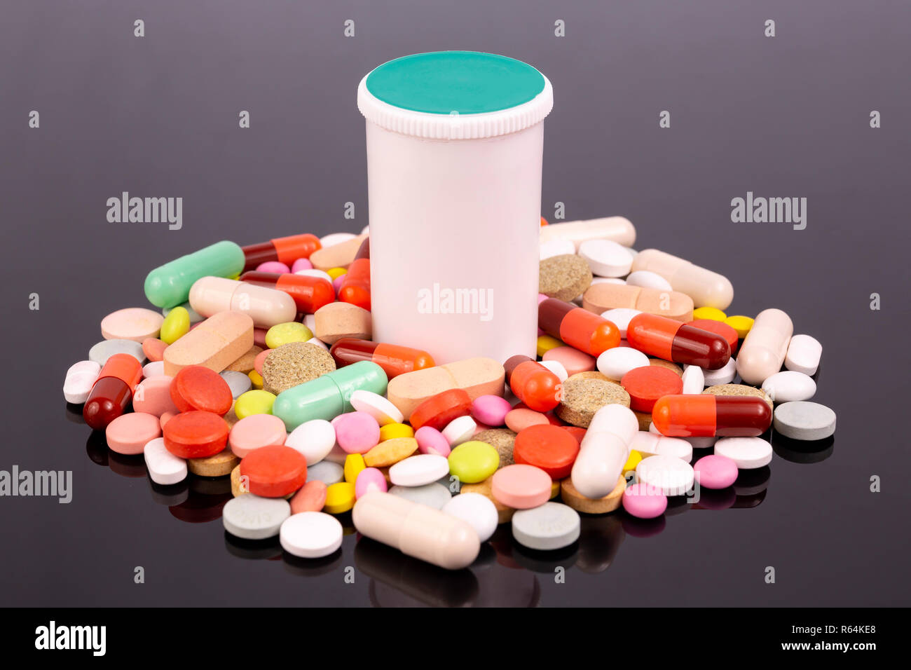 Pilules colorées différentes, des capsules de bouteilles en plastique blanc et noir isolé sur une surface réfléchissante. Industrie pharmaceutique mondiale pour des milliards de dollars Banque D'Images