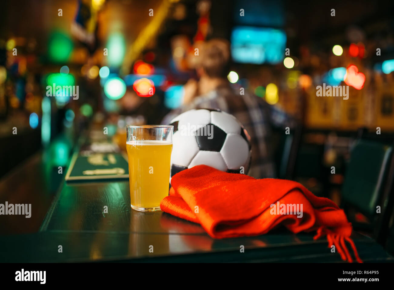 Ball, bière et foulard rouge sur le comptoir dans un bar sportif, les fans de football de vie. La diffusion TV, regarder le jeu concept Banque D'Images