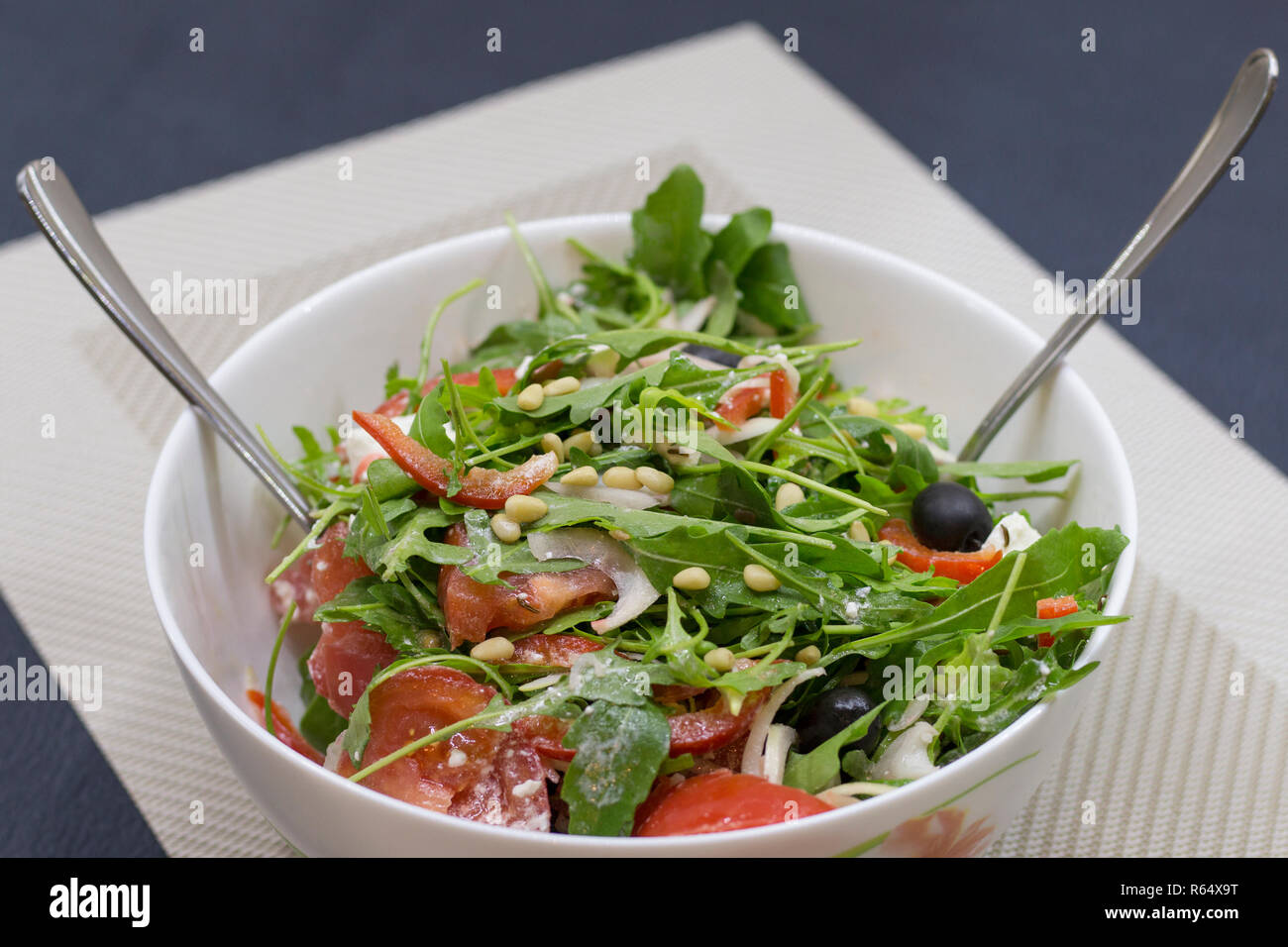 Salade végétarienne maison avec tomates, oignons, olives, roquette, brynza et d'huile d'olive. Recette avec les noix de pin et de cumin Banque D'Images