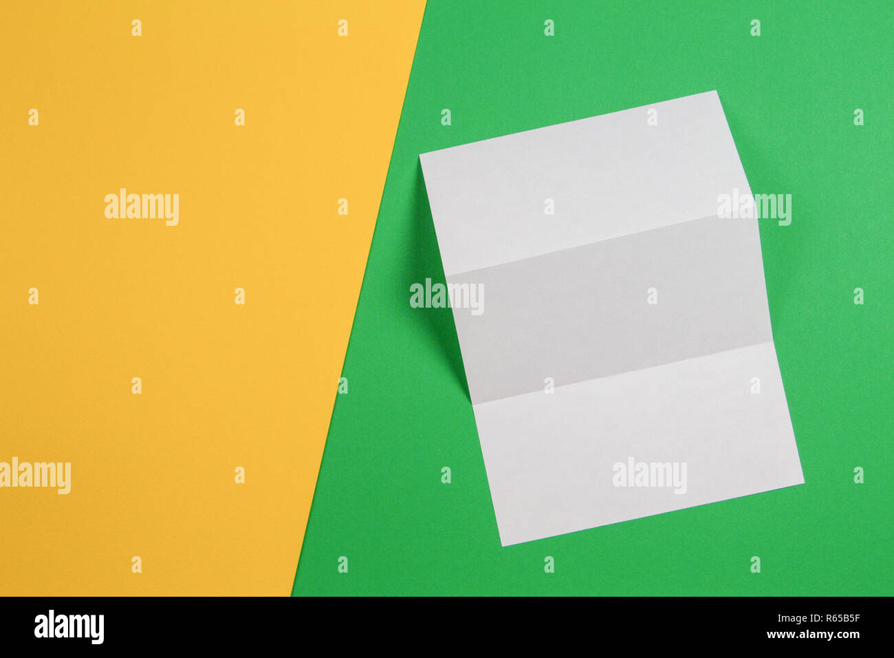 Maquette de blank white tri fold brochure brochure sur fond jaune et vert Banque D'Images