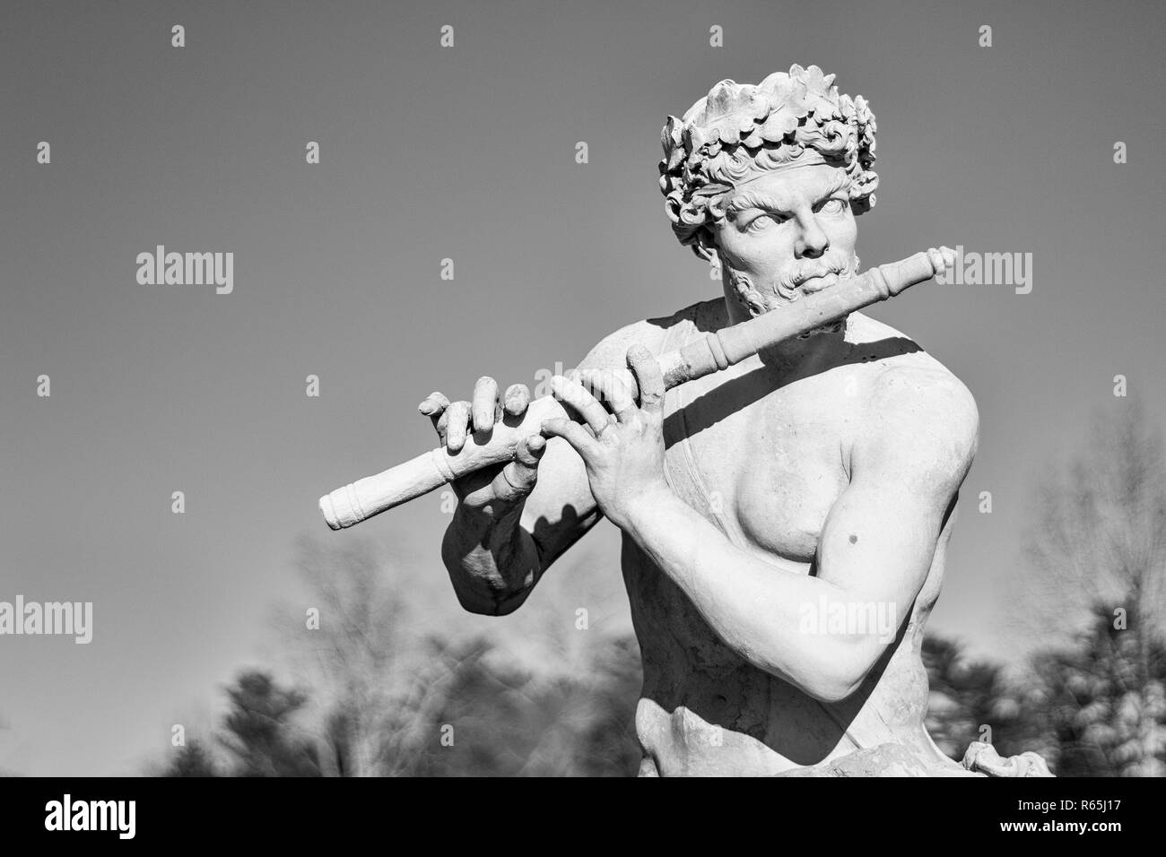 Une 17e siècle sculpture en terre cuite de Pan jouant de la flûte s'affiche dans la stark soleil éclatant et ciel bleu, au Biltmore Estate à Asheville, NC, USA Banque D'Images