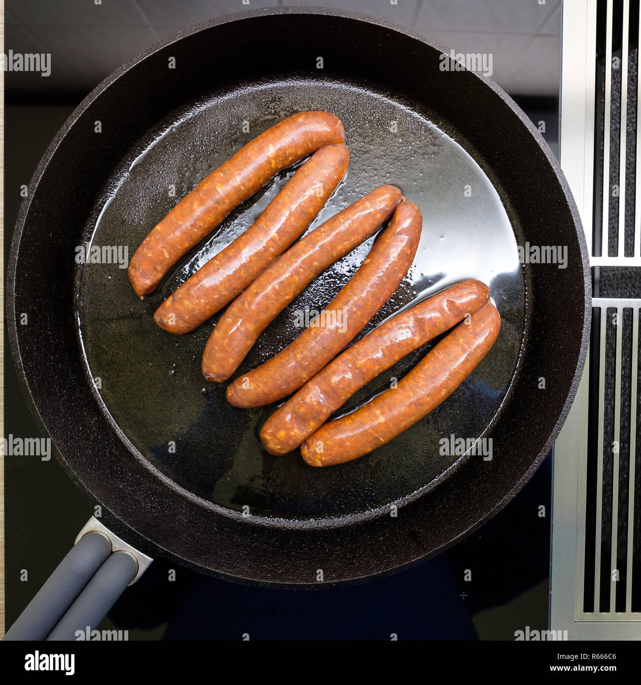 Vue de dessus de saucisses frites merquez dans une casserole sur la cuisinière Banque D'Images