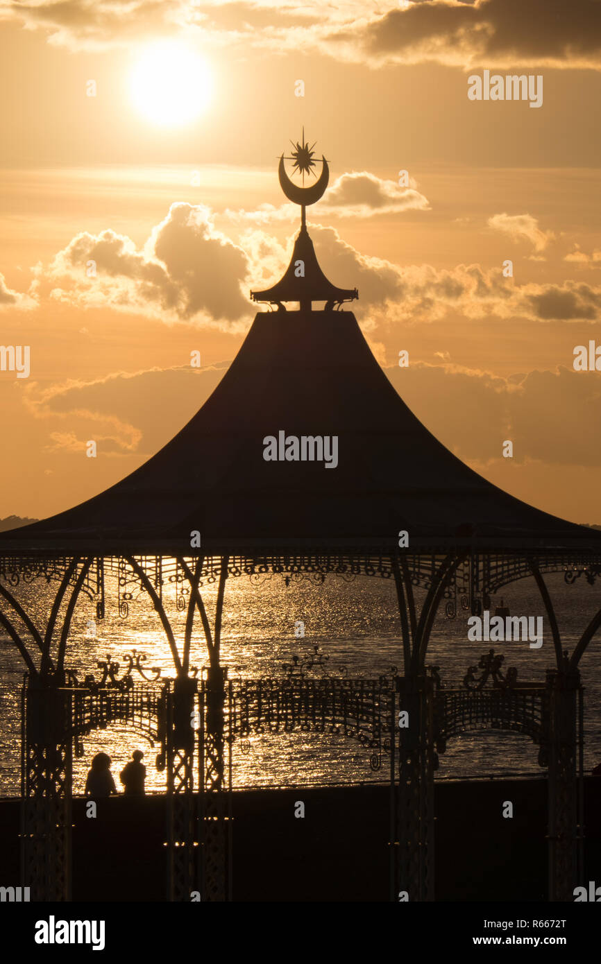Les personnes qui marchent le long de Southsea Promenade au coucher du soleil après le stand du groupe Banque D'Images