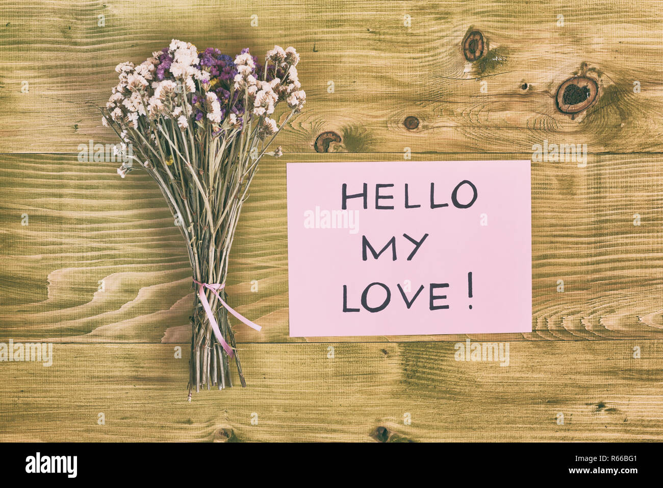 Bouquet de fleurs avec message salut mon amour sur table en bois. Banque D'Images