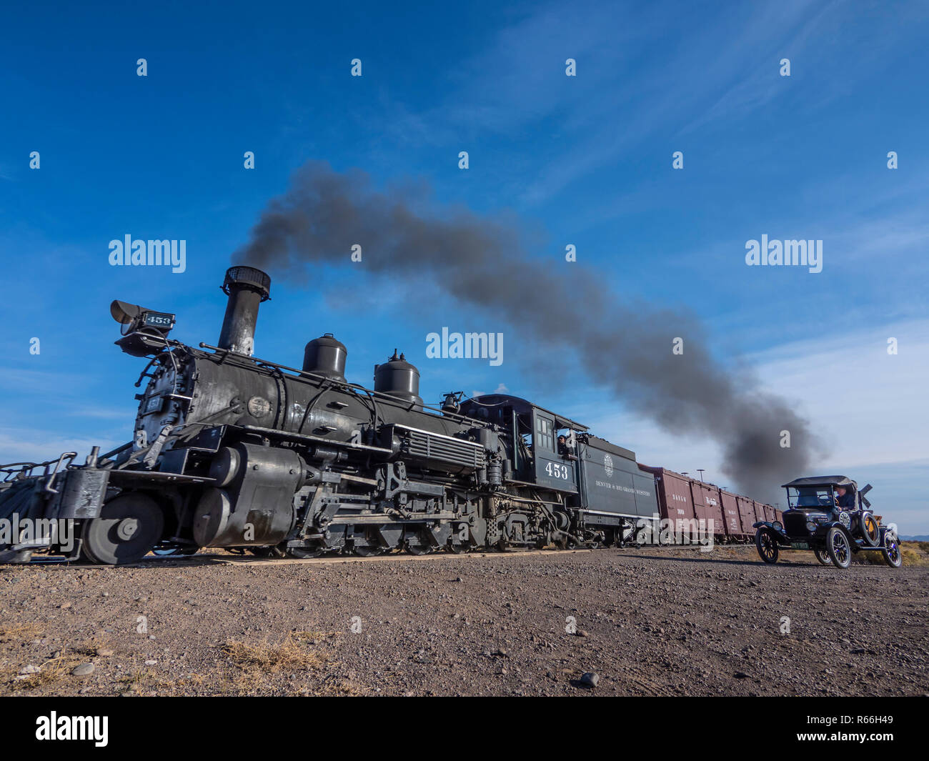Locomotive à vapeur 453 approches de trains de marchandises du chemin de comté E5 croisement avec un modèle-t'attendre par les voies. Banque D'Images