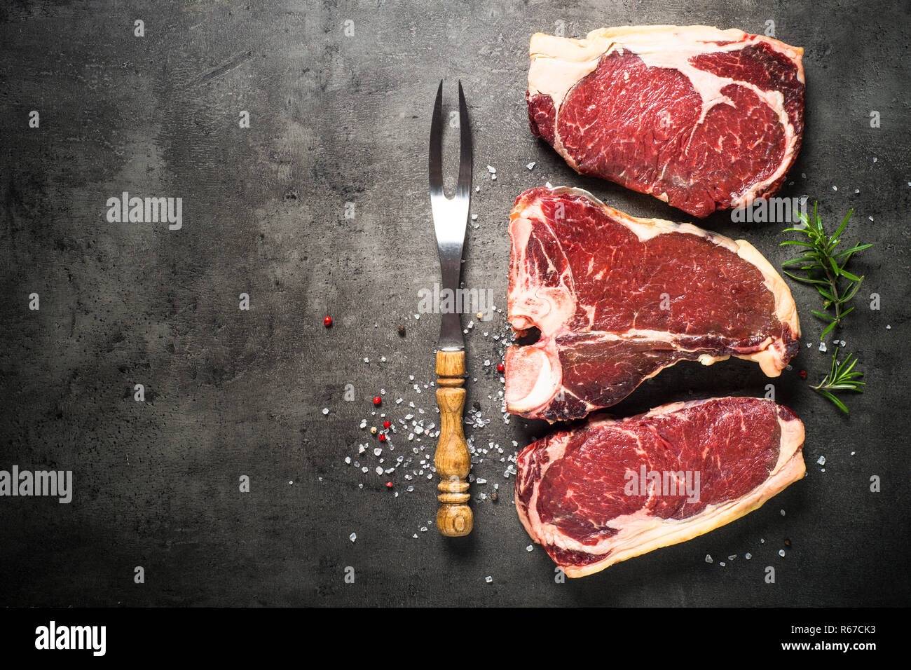 Le bœuf vieilli à sec - steaks de contre-filet, faux-filet, t-bone steaks sur noir Banque D'Images