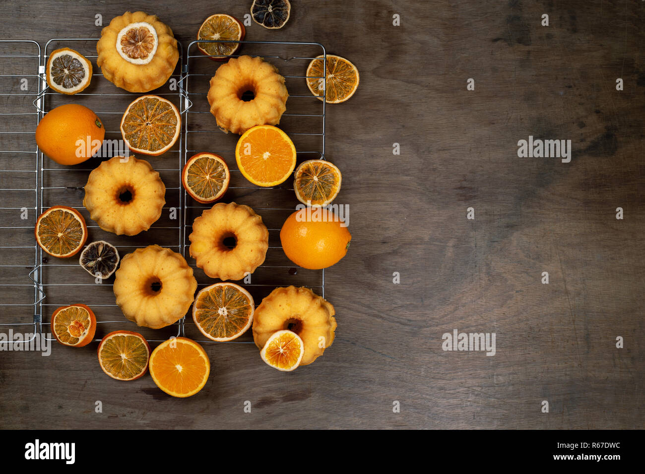 Petits gâteaux Bundt orange avec des oranges fraîches et sèches sur le refroidissement ruck, haut Vue, télévision lay, copy space Banque D'Images