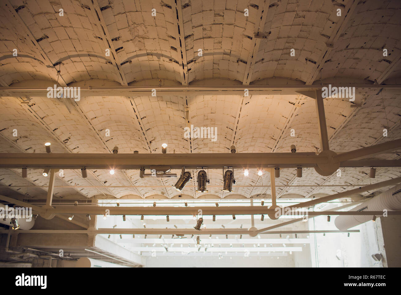 Lumières et système de ventilation en longue ligne sur plafond du bâtiment industriel bureau sombre, Hall d'exposition d'un plafond. Banque D'Images