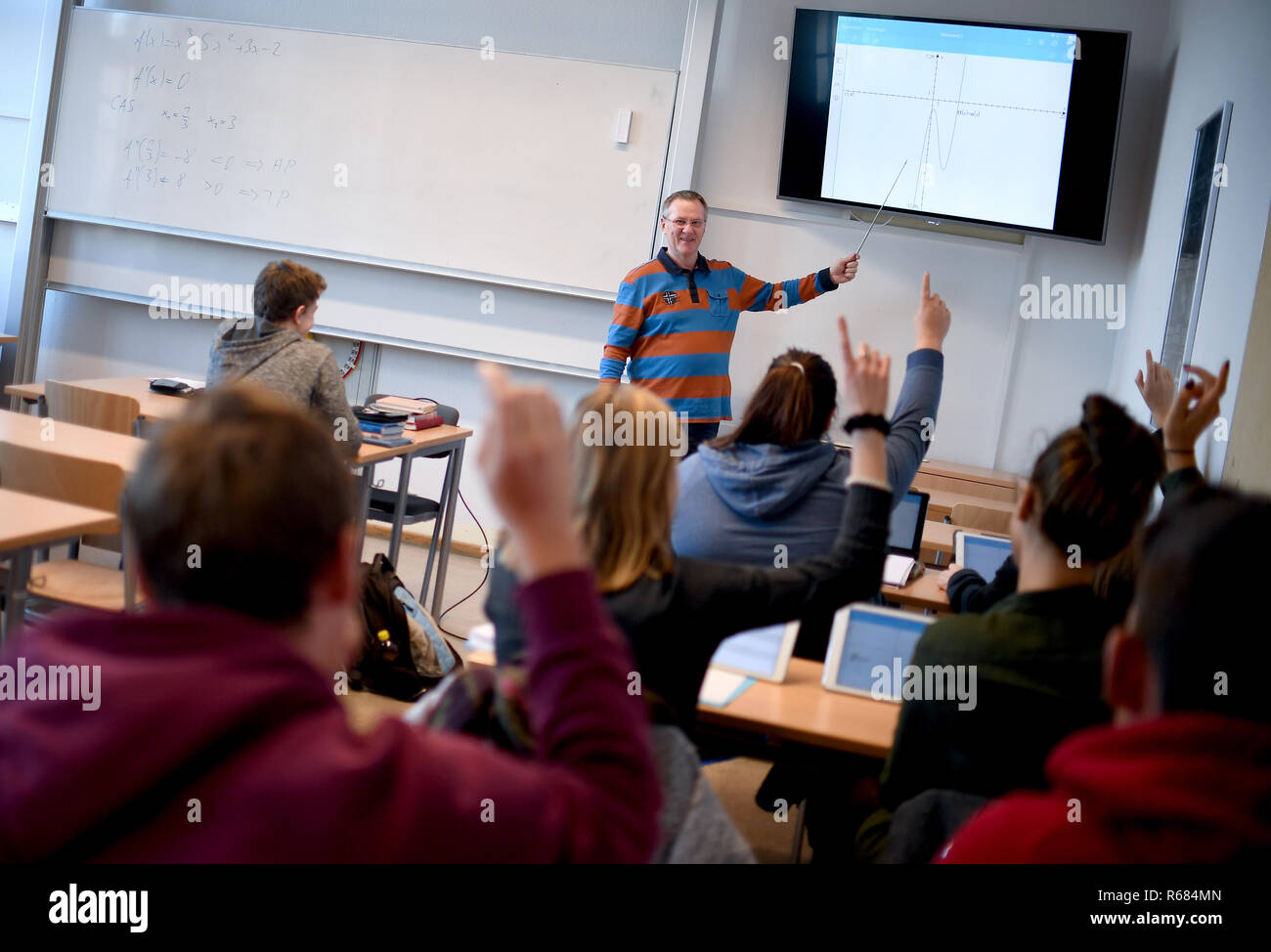 28 novembre 2018, Berlin, Neustrelitz : Hans-Herbert Gmbh, enseignant au gymnase Carolinum à Neustrelitz, donne des leçons de mathématiques sur un écran. Ses étudiants travaillent avec des IPAD en classe. Photo : Britta Pedersen/dpa-Zentralbild/ZB Banque D'Images