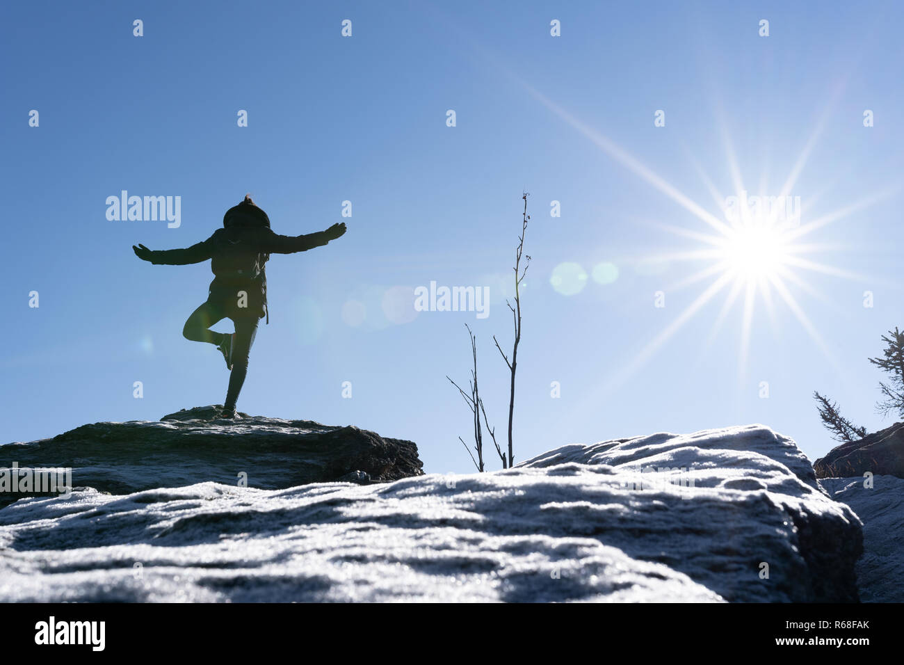 Jeune femme est en train de faire du yoga sur un pic de montagne avec de la glace à l'avant-plan. Forêt de Bavière, Allemagne, osser. Banque D'Images