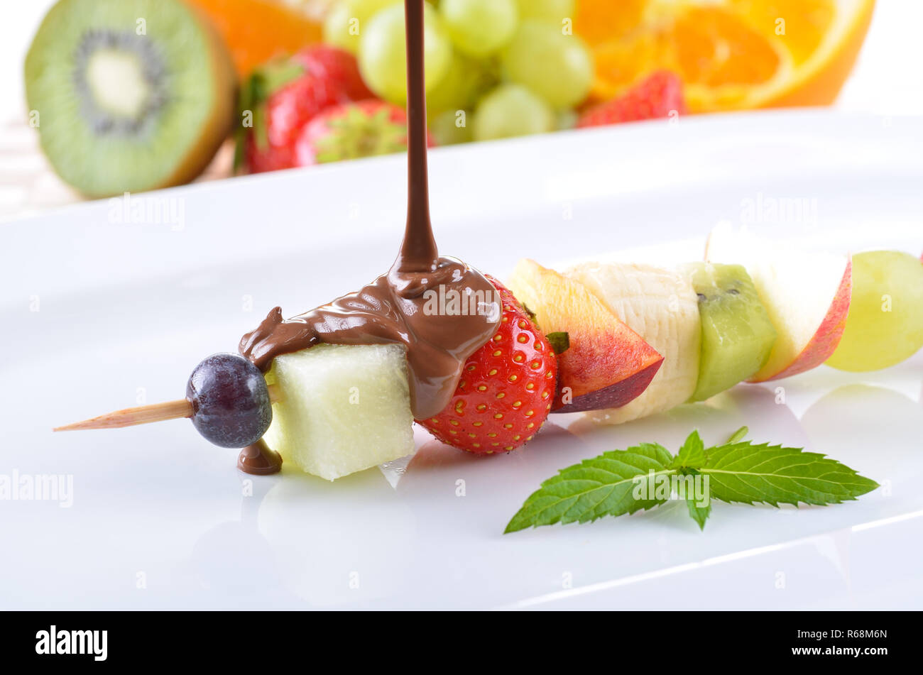 Fruit d'été mûres en saison sur une brochette avec chocolat au lait Banque D'Images