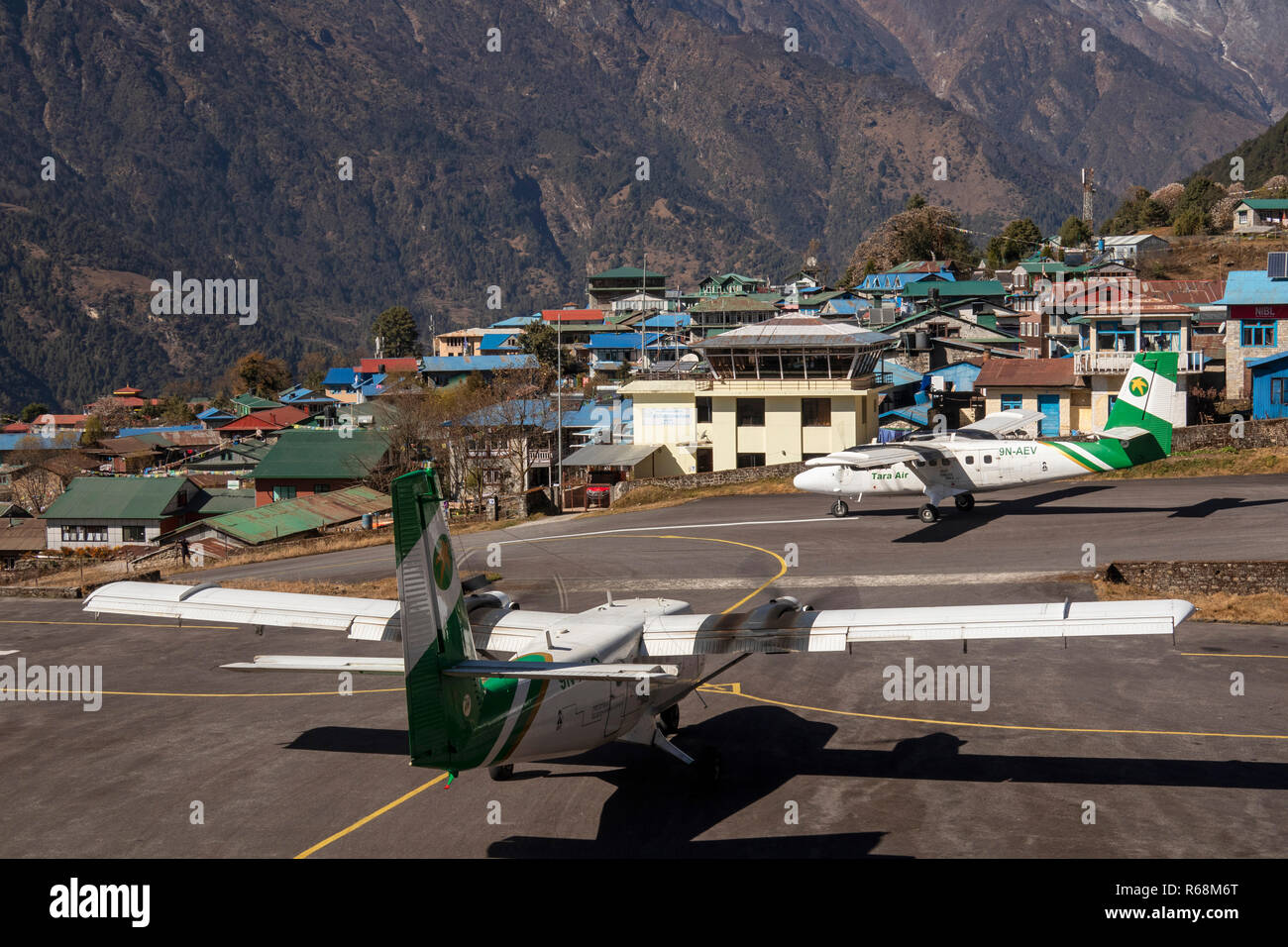 L'aéroport de Lukla, Népal, Tara Air, Dornier 228-212 avions qui décollent de la piste à haute altitude et un autre taxis Banque D'Images