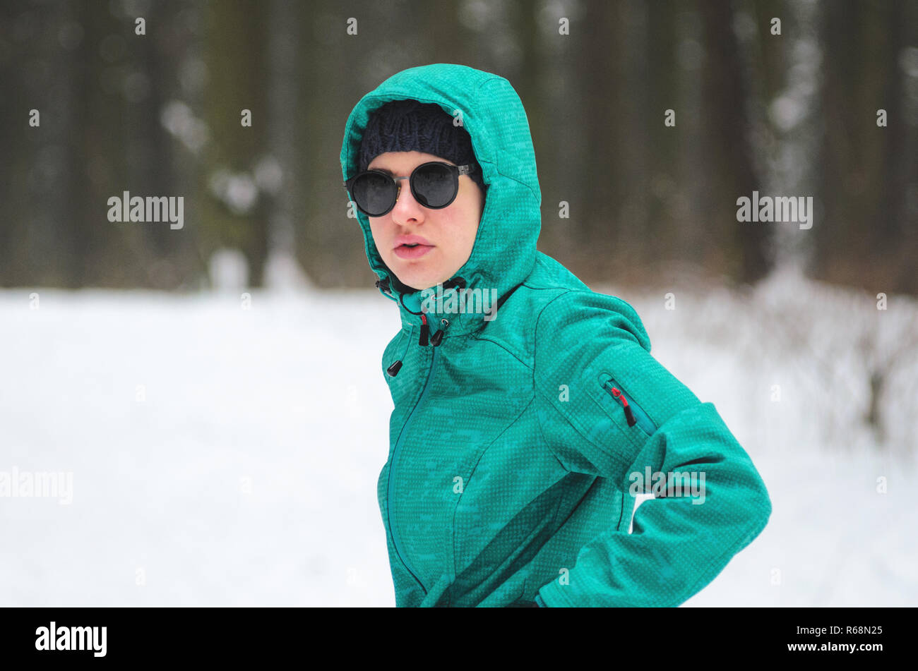 Portrait d'un athlète cycliste féminine en lunettes de soleil dans la forêt d'hiver. Le cycliste de vélo de cyclocross dans la forêt enneigée en hiver. Worko Hiver Banque D'Images