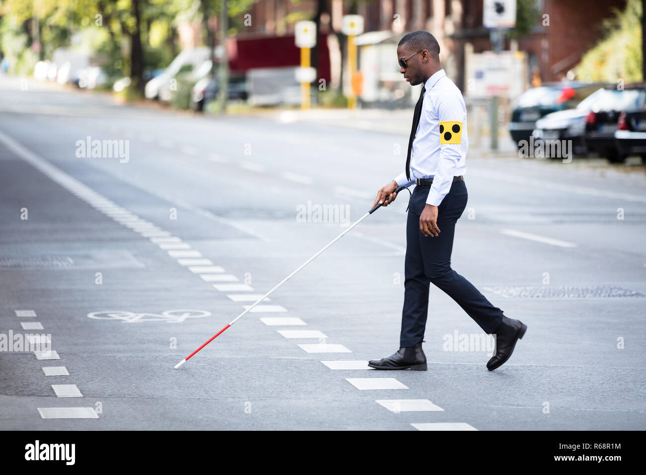 Blind Man Wearing Armband Marcher avec Stick Banque D'Images