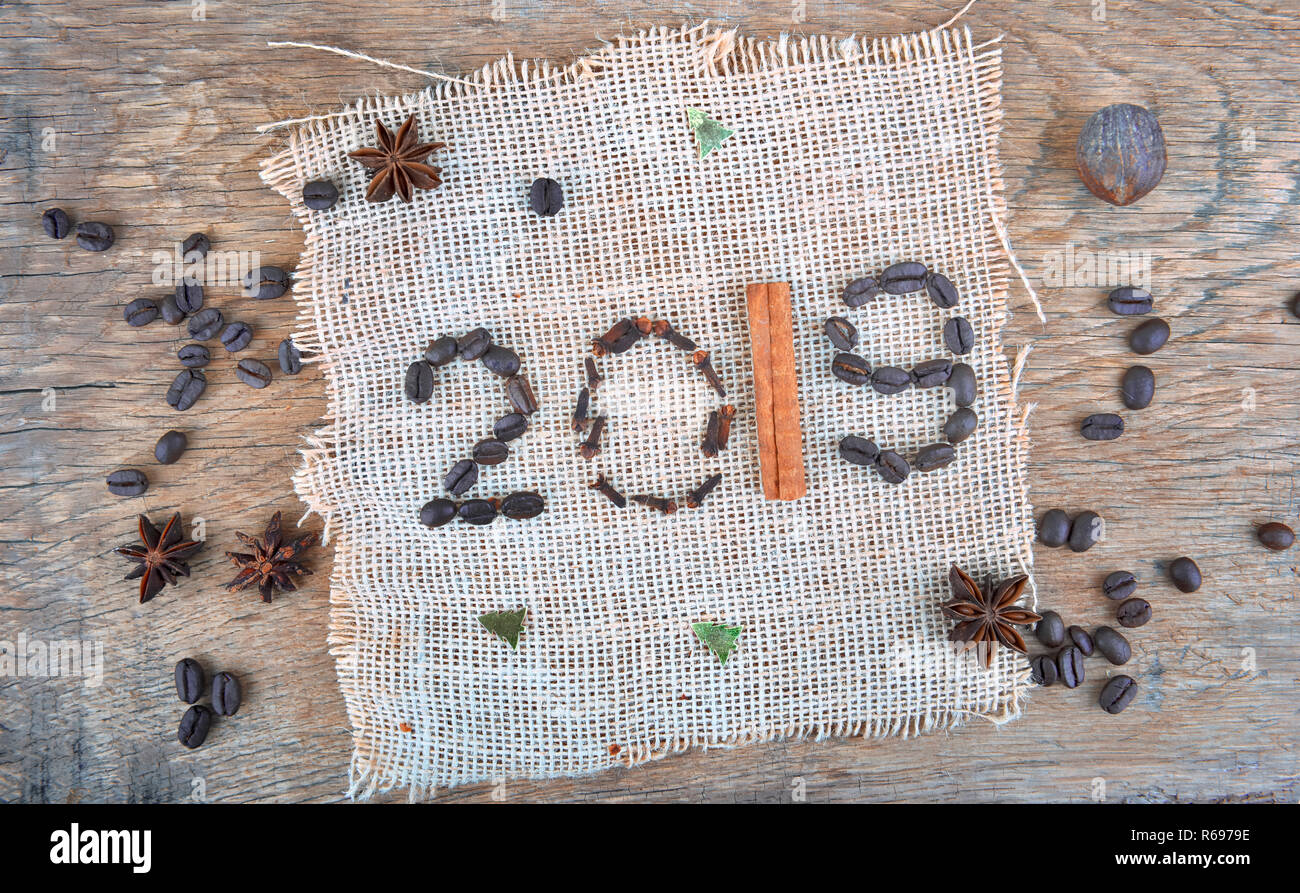 L'année 2019 rédigée avec les épices et les haricots sur du tissu café mis texturé sur une planche Banque D'Images