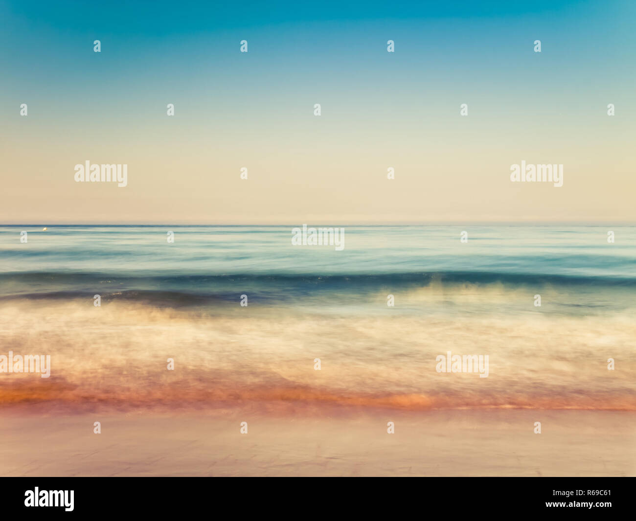 Motion Blurred douces vagues éclabousser dans la matinée sur la plage de sable Banque D'Images