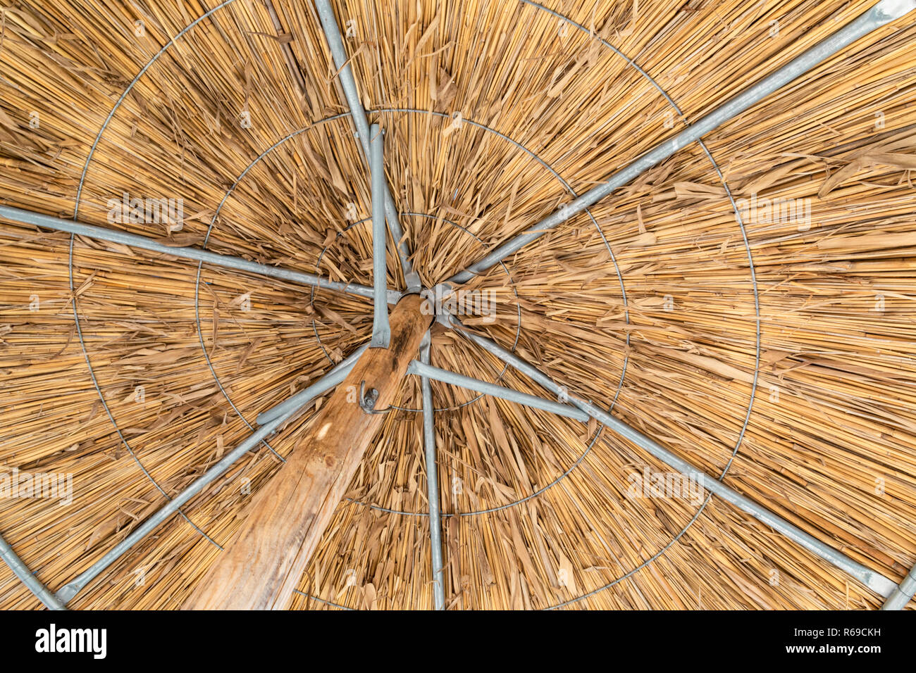 Tourné à partir de ci-dessous de l'intérieur d'un parasol en paille avec une structure en bois et en métal. Banque D'Images