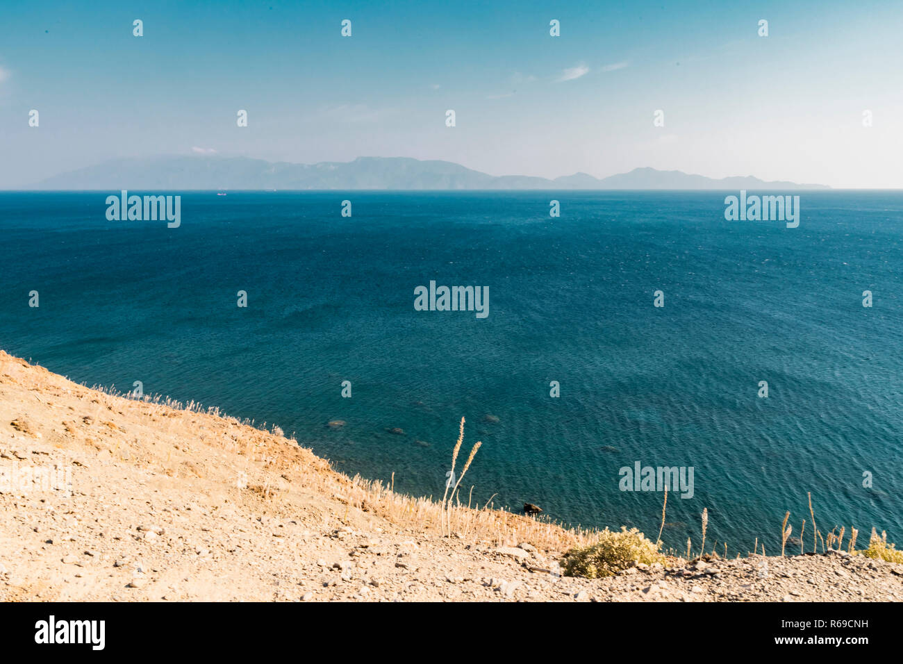 Paysage d'une vaste mer turquoise d'une falaise, avec des îles volcaniques dans l'arrière-plan sur la ligne d'horizon. Banque D'Images