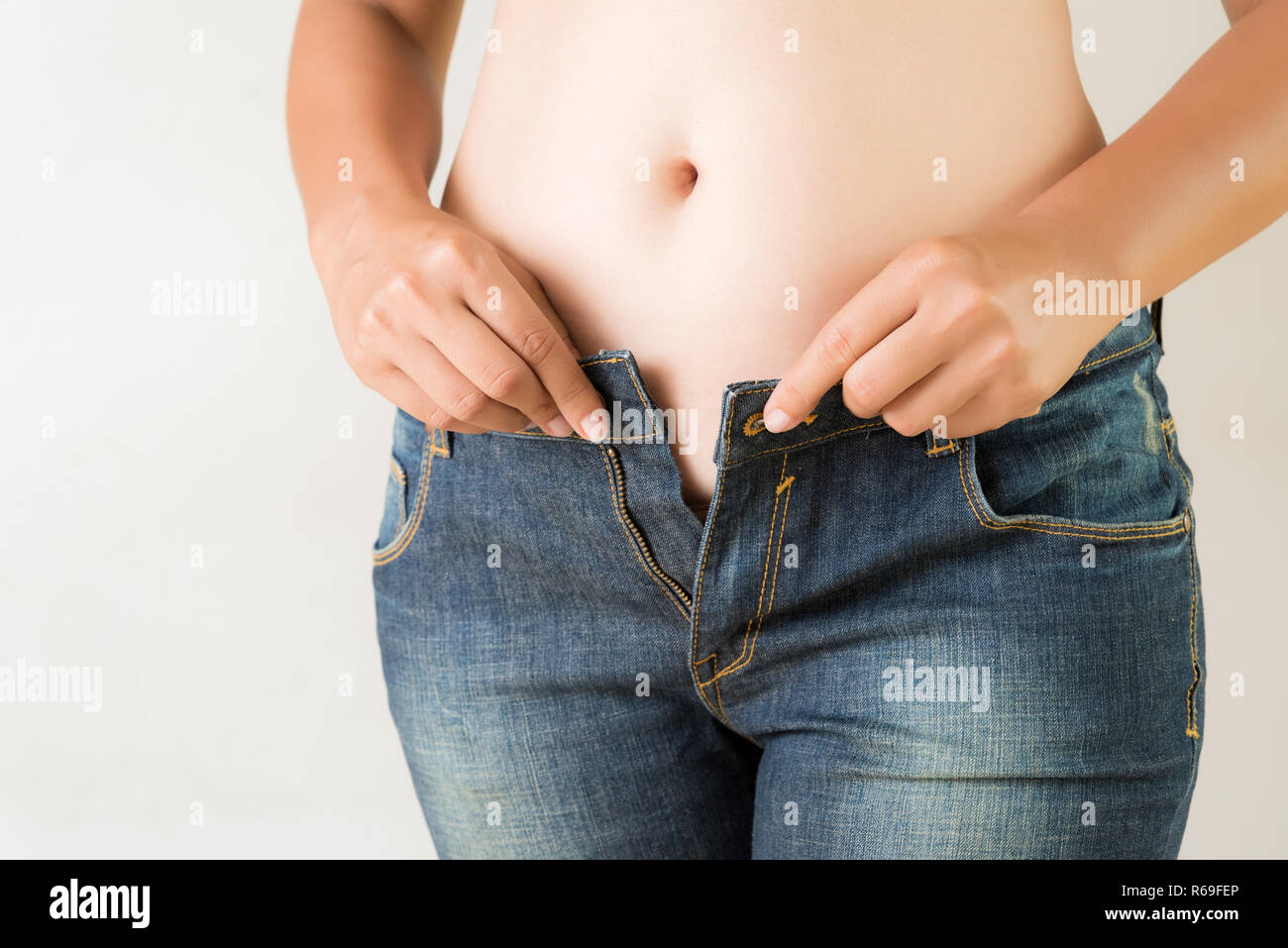 L'excès de grosse femme portant des jeans. L'estomac de perte de poids libre. Skinny jeans slim fit sur une saine administration. Concept de régime. Banque D'Images