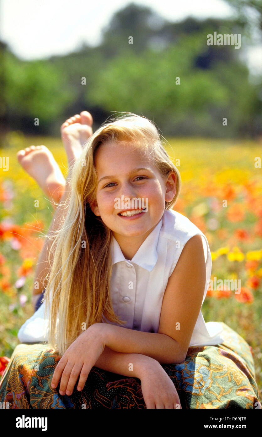 Portrait Laechelndes Maedchen Mit Langen Blondn Haaren 12 Jahre Mit Weisser Blouse Aermellosen Sitzt Auf Einer Mit Gelben Und Klatschmohn Blueten Uebersaeten Wiese Photo Stock Alamy