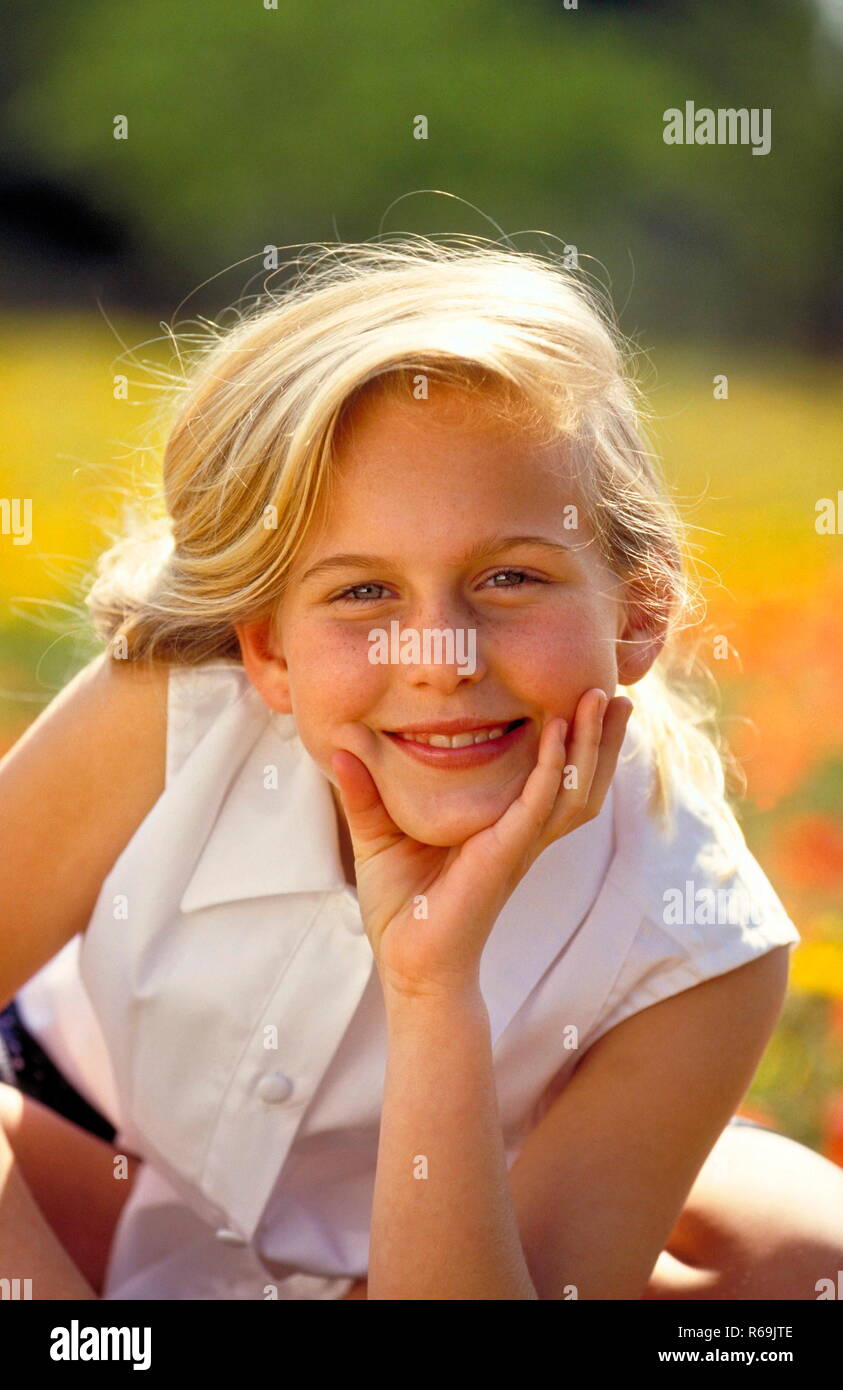 Portrait Laechelndes Maedchen Mit Langen Blondn Haaren 12 Jahre Mit Weisser Blouse Aermellosen Sitzt Auf Einer Mit Gelben Und Klatschmohn Blueten Uebersaeten Wiese Photo Stock Alamy