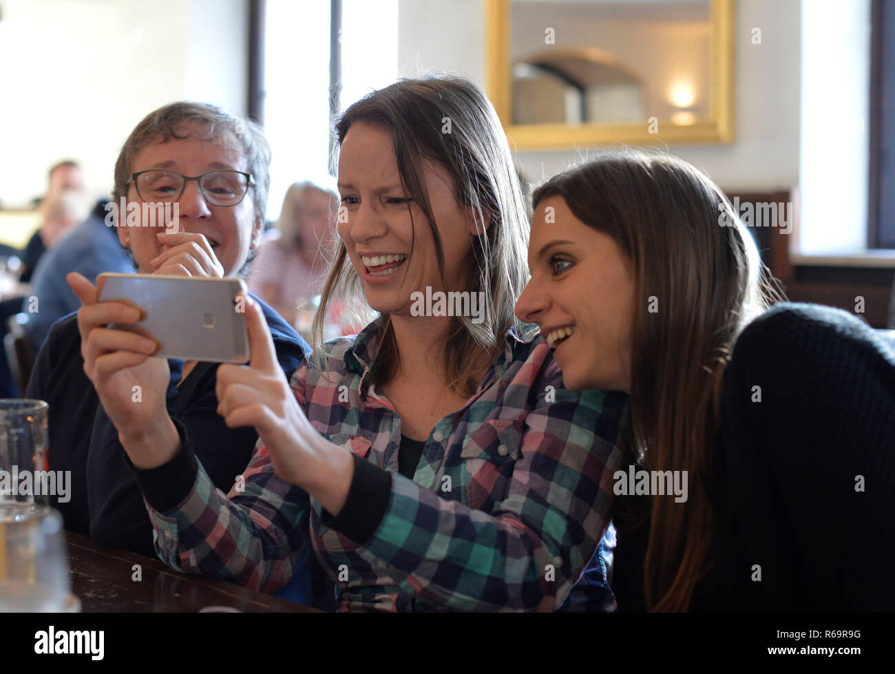 Les jeunes femmes et les femmes plus âgées Voir Smartphone, rire, Portrait, Café, Stuttgart, Bade-Wurtemberg, Allemagne Banque D'Images