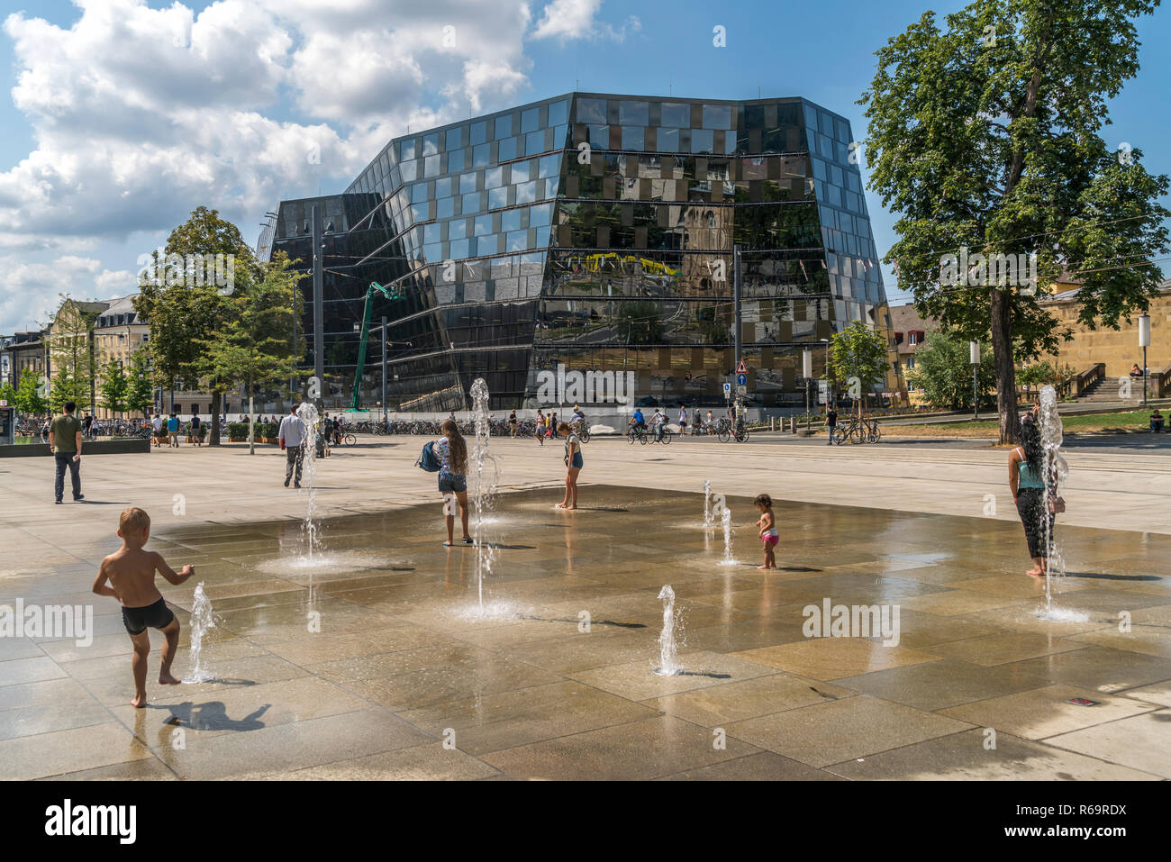 Enfants qui jouent à la fontaine en face de la bibliothèque de l'université de Fribourg-en-Brisgau, Forêt Noire, Bade-Wurtemberg Banque D'Images