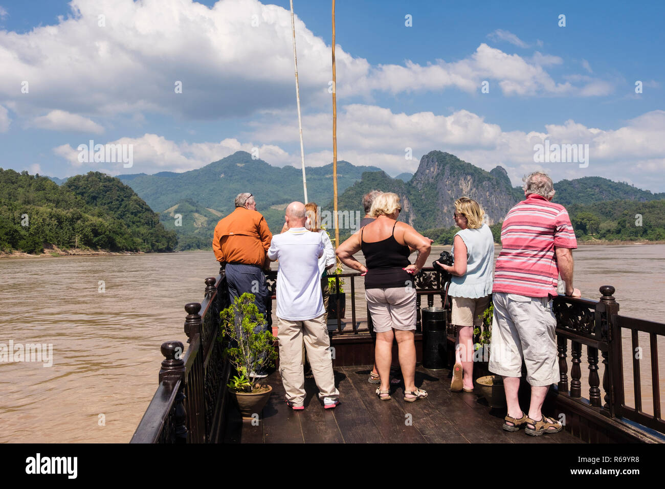 Les touristes à la recherche de paysages à voir à bord d'un bateau traditionnel en bois de croisière le Mékong à partir de Luang Prabang, Louangphabang province, Laos, Asie Banque D'Images