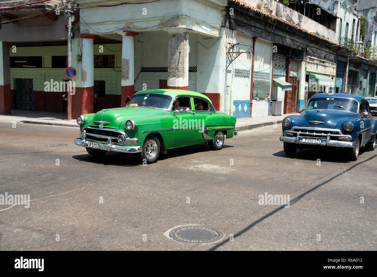 Deux vintage des années 50 nous les voitures qui circulent dans les rues en ruines de La Havane Cuba Banque D'Images
