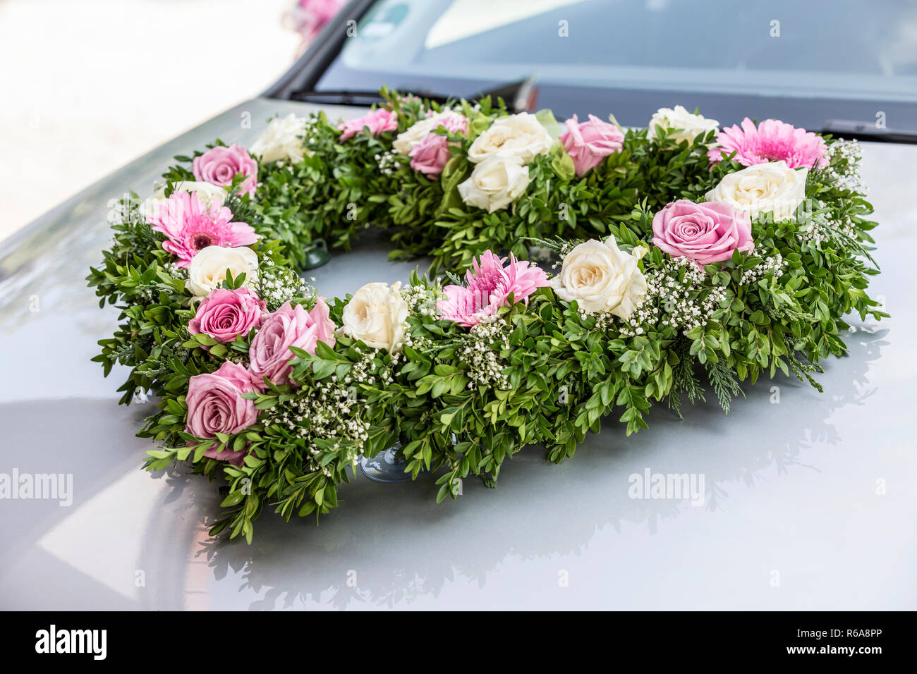Heart-Shaped Voiture mariée Bouquet de roses blanches et roses sur voiture gris Banque D'Images