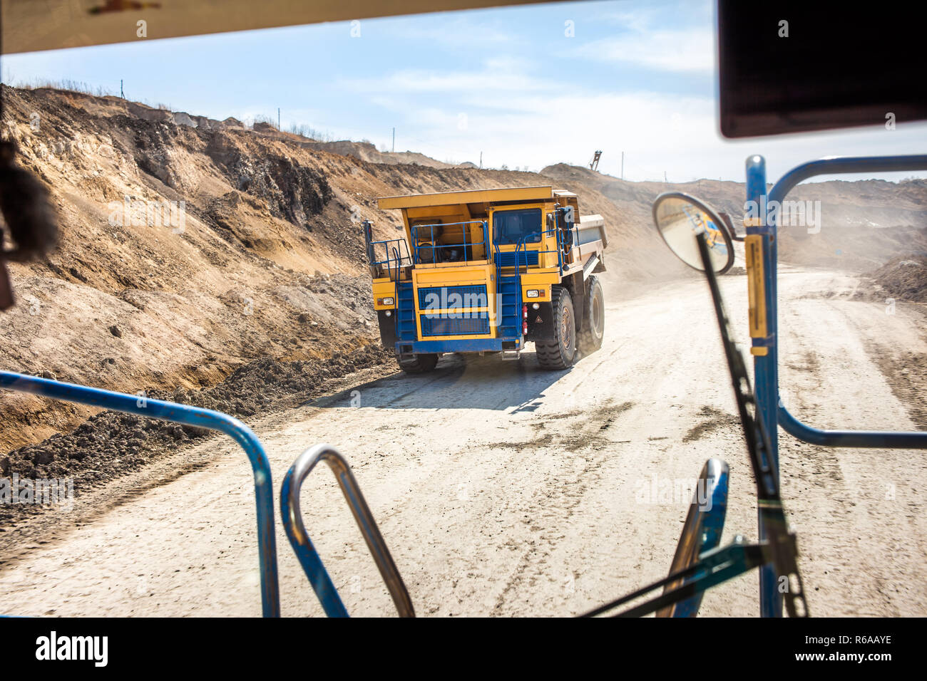 Camion benne jaune se déplaçant dans une mine de charbon. Vue depuis un autre camion Banque D'Images