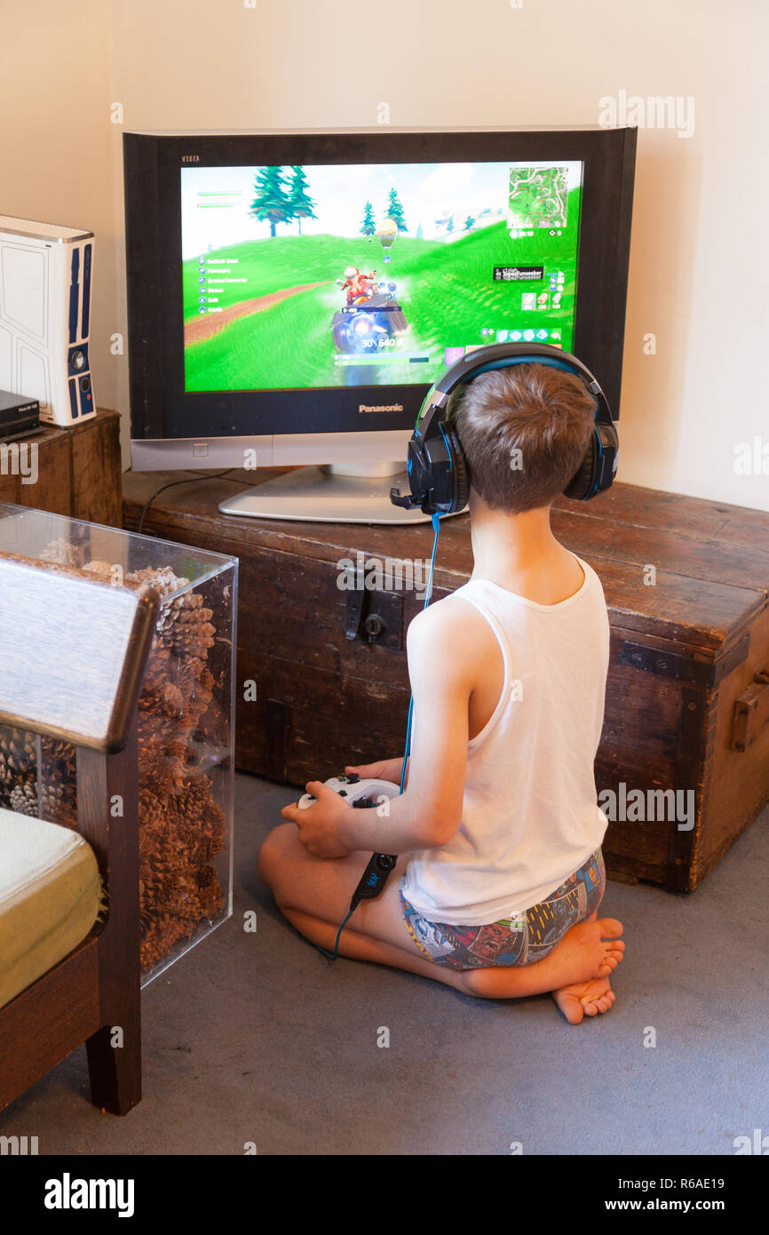 Neuf ans, garçon jouant sur la Xbox portant des écouteurs, Hampshire, Angleterre, Royaume-Uni. Banque D'Images