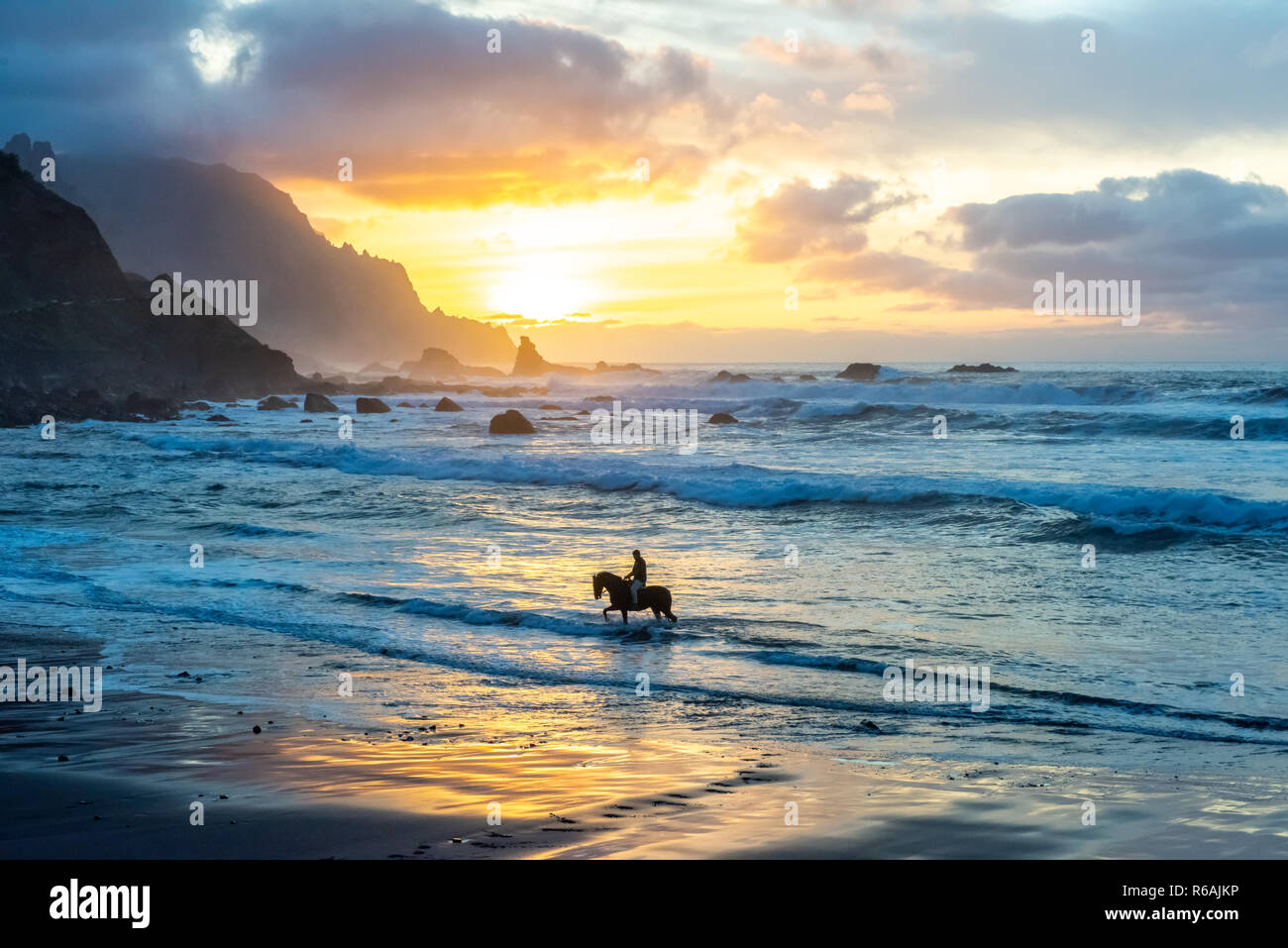 L'homme l'équitation sur sunset beach Banque D'Images