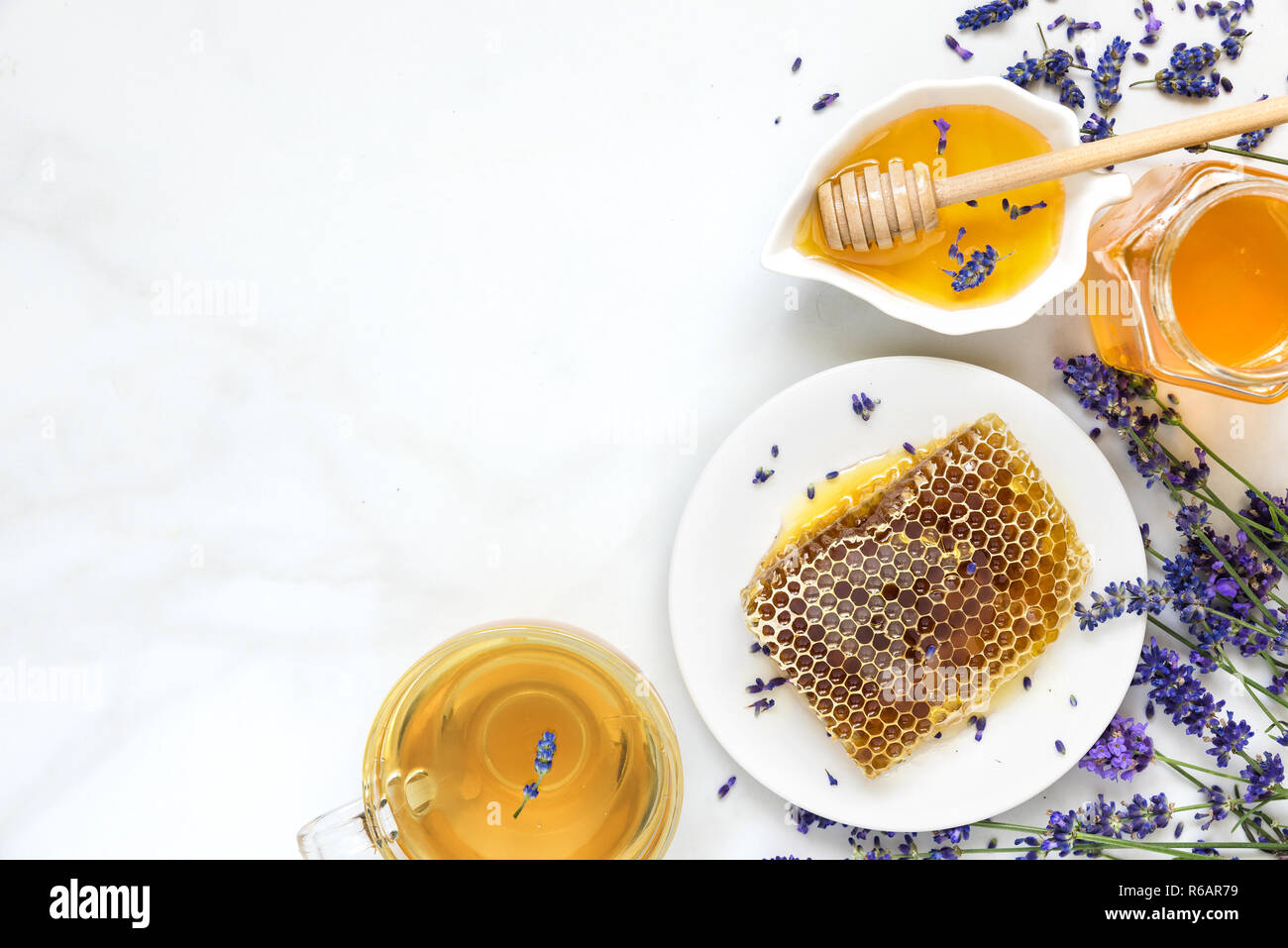 Le miel de lavande et de thé d'abeilles avec freash fleurs sur table de marbre blanc. alimentation saine. top view with copy space Banque D'Images Le miel de lavande et de thé d'abeilles avec freash fleurs sur table de marbre blanc. alimentation saine. top view with copy space Banque D'Images