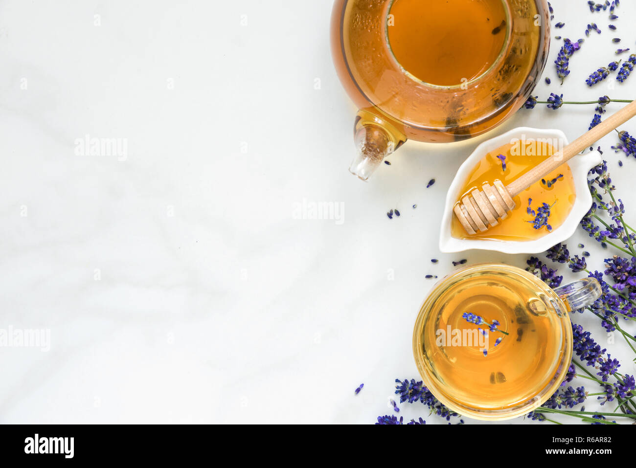 Thé de lavande dans une tasse et une théière avec du miel et des fleurs fraîches sur la table en marbre blanc de fines herbes. boire. top view with copy space Banque D'Images Thé de lavande dans une tasse et une théière avec du miel et des fleurs fraîches sur la table en marbre blanc de fines herbes. boire. top view with copy space Banque D'Images