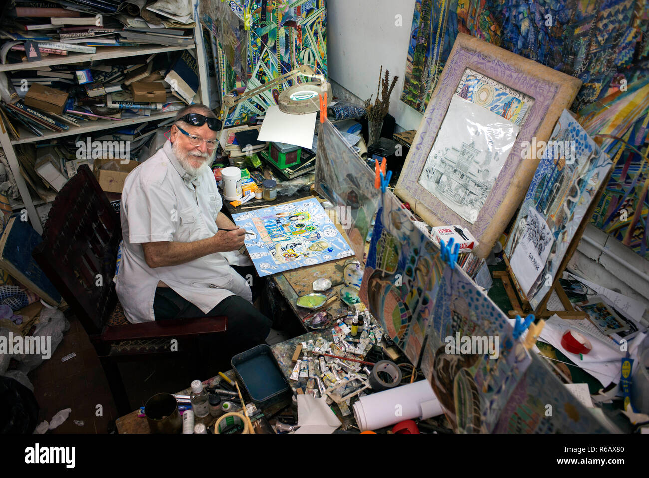 Michael Adams peintre assis dans son studio à Anse Poules bleues, l'île de Mahé, Seychelles. Baie Lazare, Anse aux poules bleues, l'artiste Michael Adams Banque D'Images