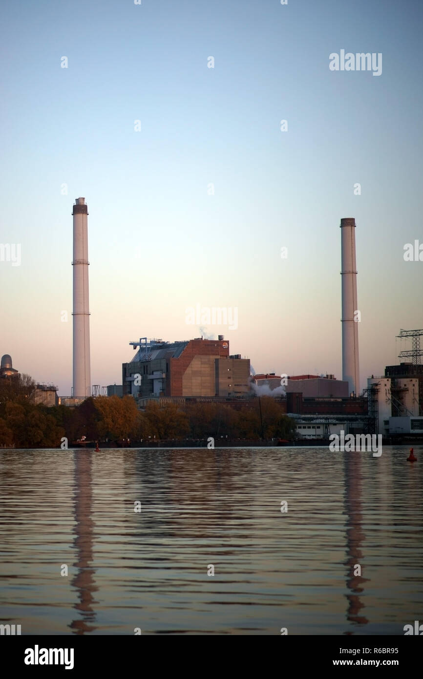 Les cheminées industrielles et bâtiments de l'ancienne usine de verre Friedrichshain sur la péninsule Stralau reflétant dans l'eau. Banque D'Images