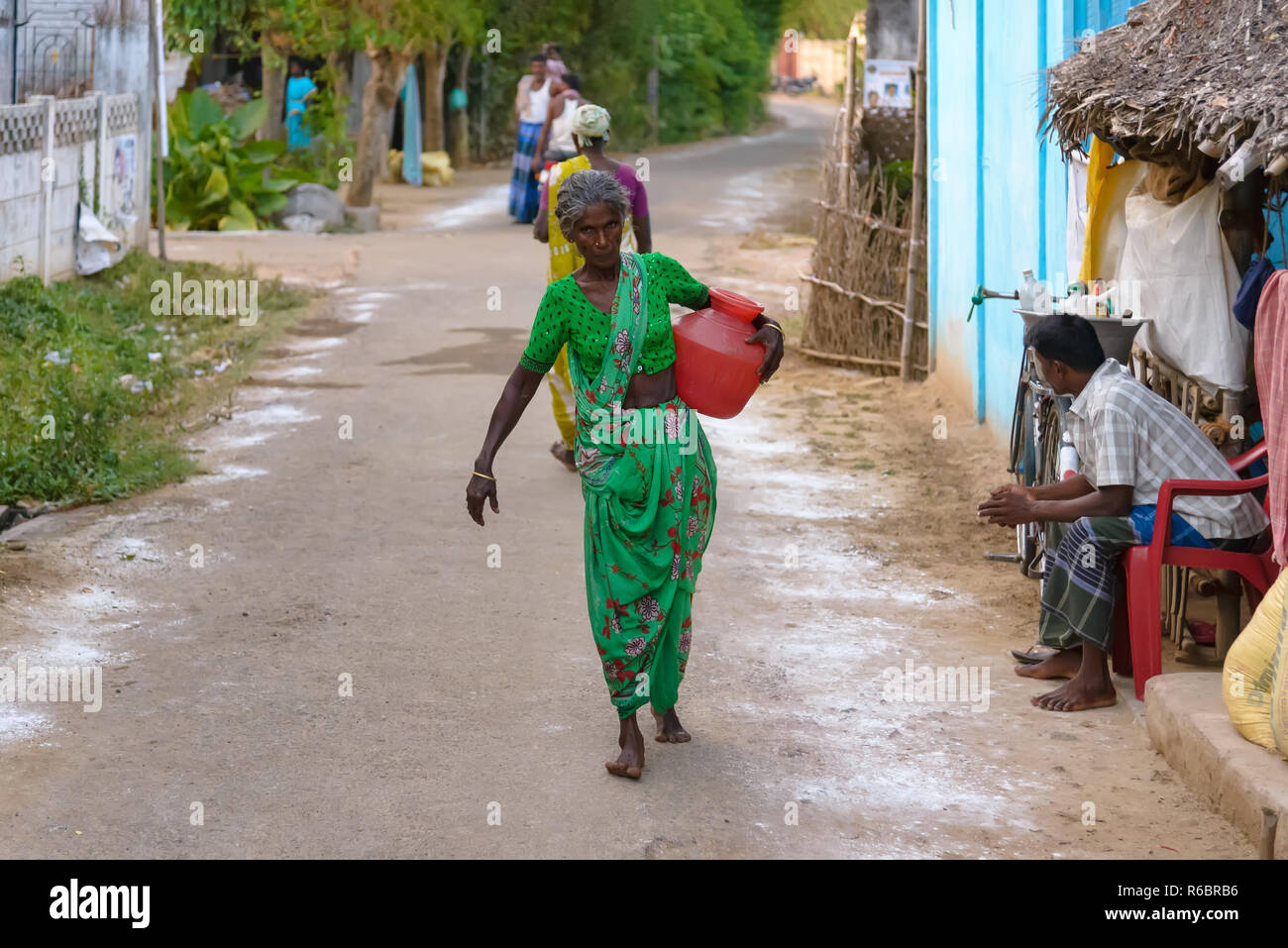 Kumbakonam, Inde - le 21 août 2018 : Vieille dame balade dans un village de campagne avec un pot dans la main Banque D'Images