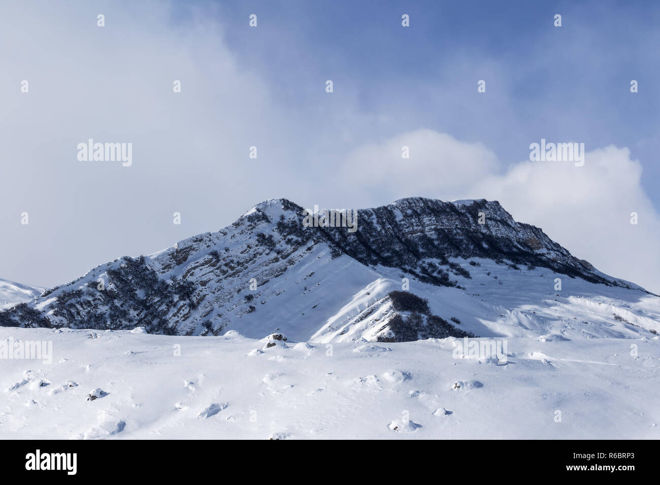 Le mont enneigé avec plage et forêt du soleil pente avec des pierres couvertes de neige. Montagnes du Caucase en hiver, Shahdagh, Azerbaïdjan. Banque D'Images