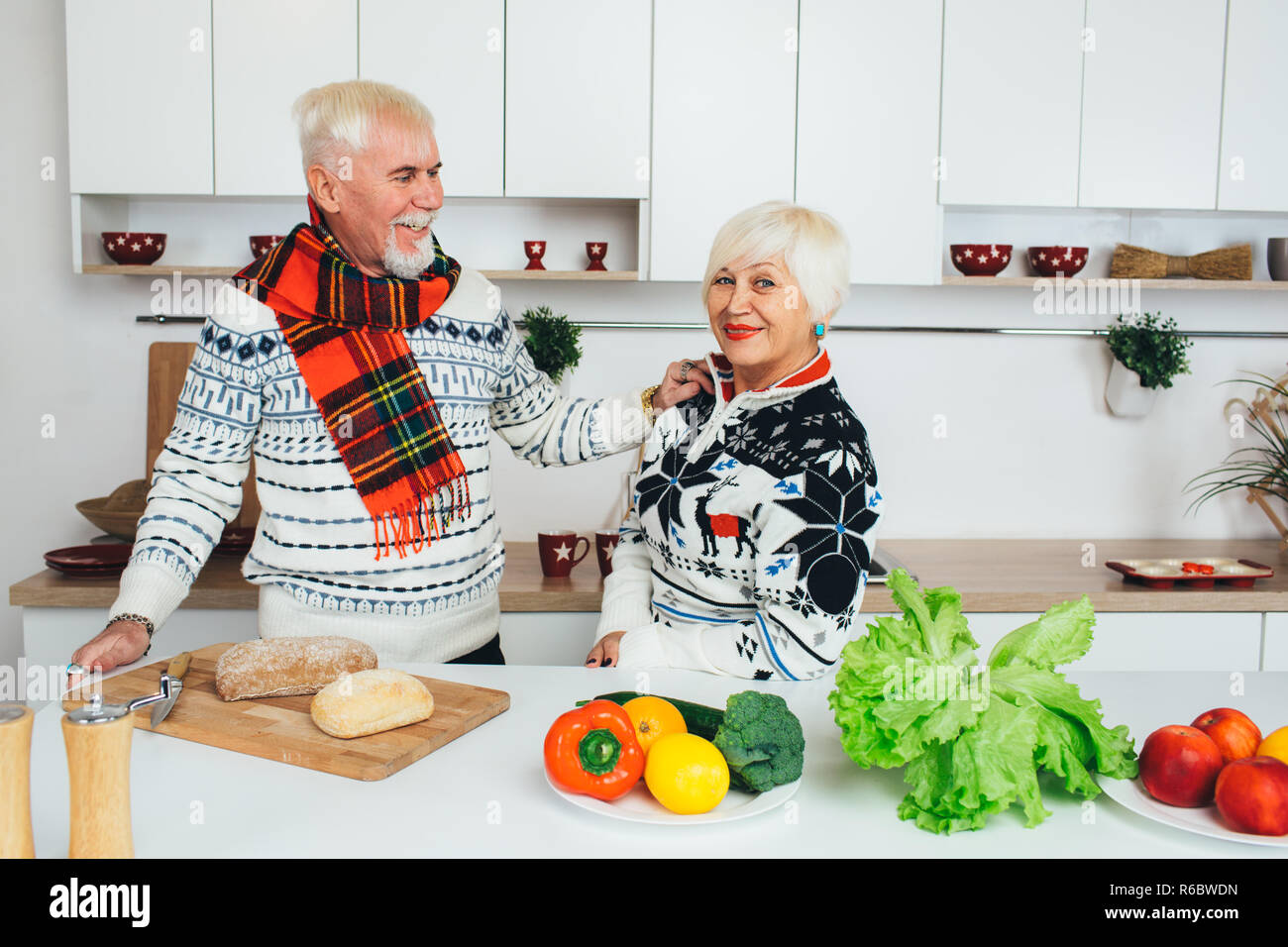 Senior couple cooking une salade végétarienne à la maison Banque D'Images