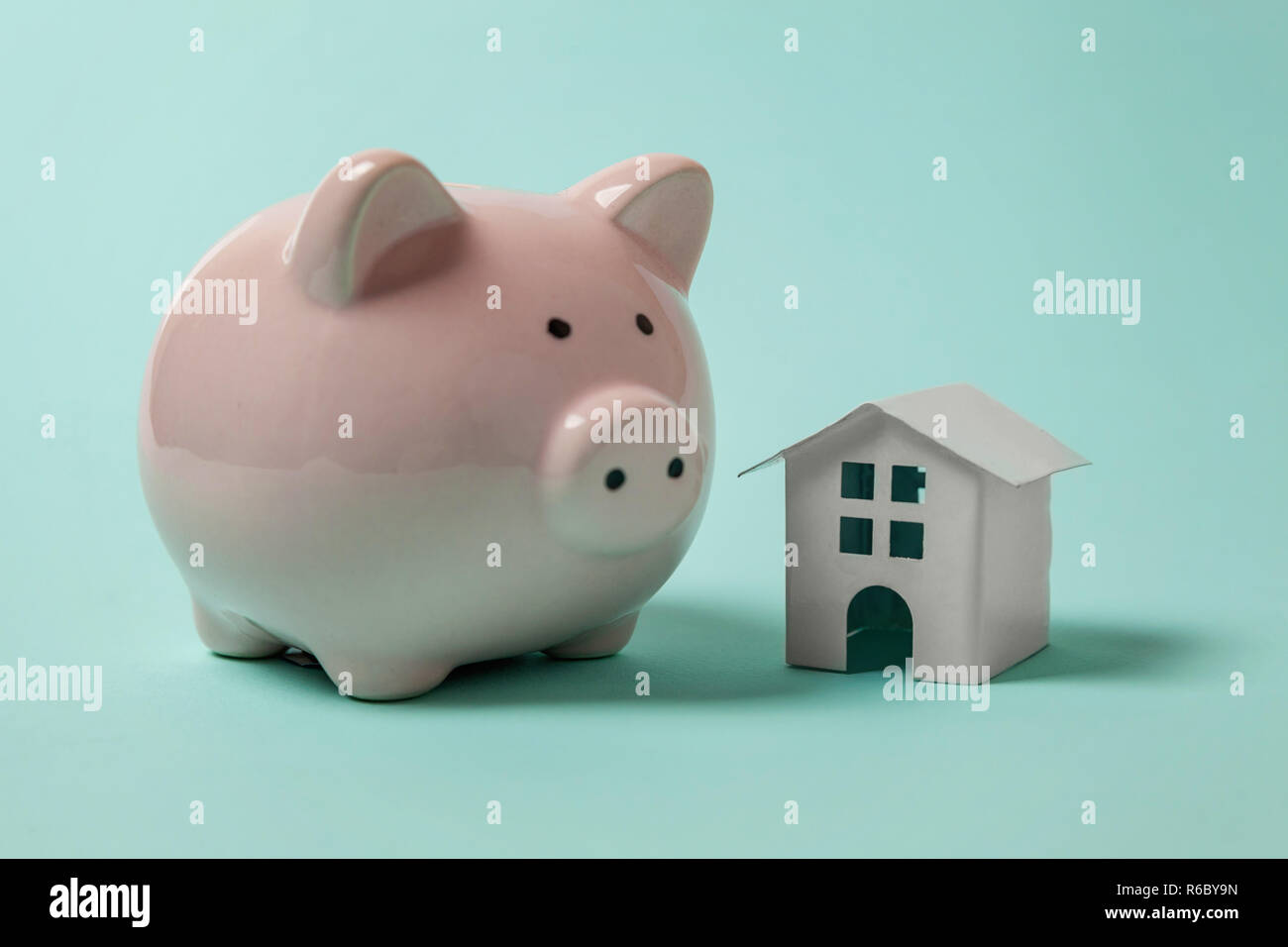 Conception simple avec miniature toy house, tirelire isolé isolé sur fond bleu pastel très tendance aux couleurs vives. L'assurance des biens hypothécaires dream home banking concept prêt à l'investissement. Copy space Banque D'Images