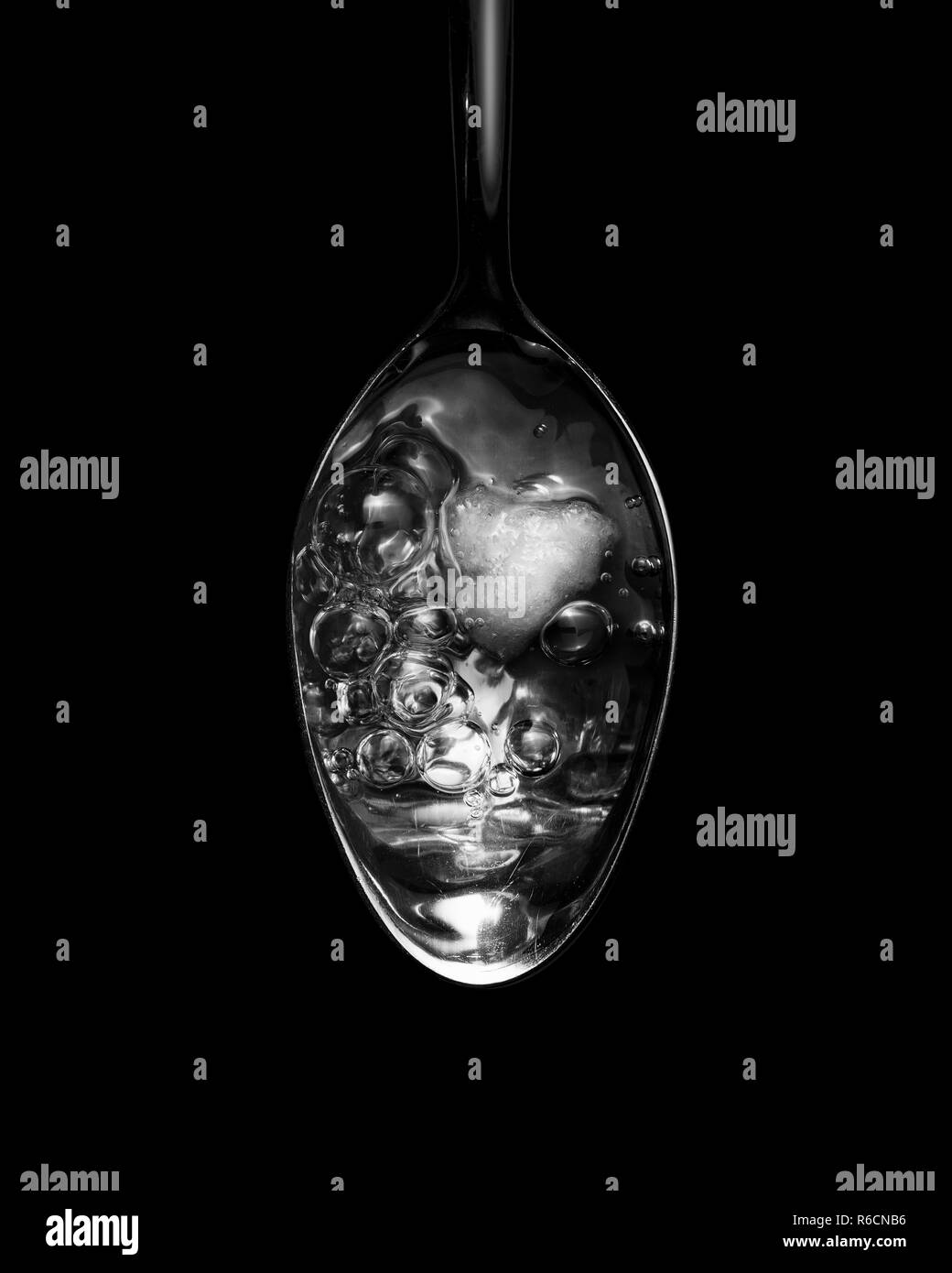 Vue en noir et blanc de l'image ci-dessus du liquide bouillonnant dans une cuillère Banque D'Images